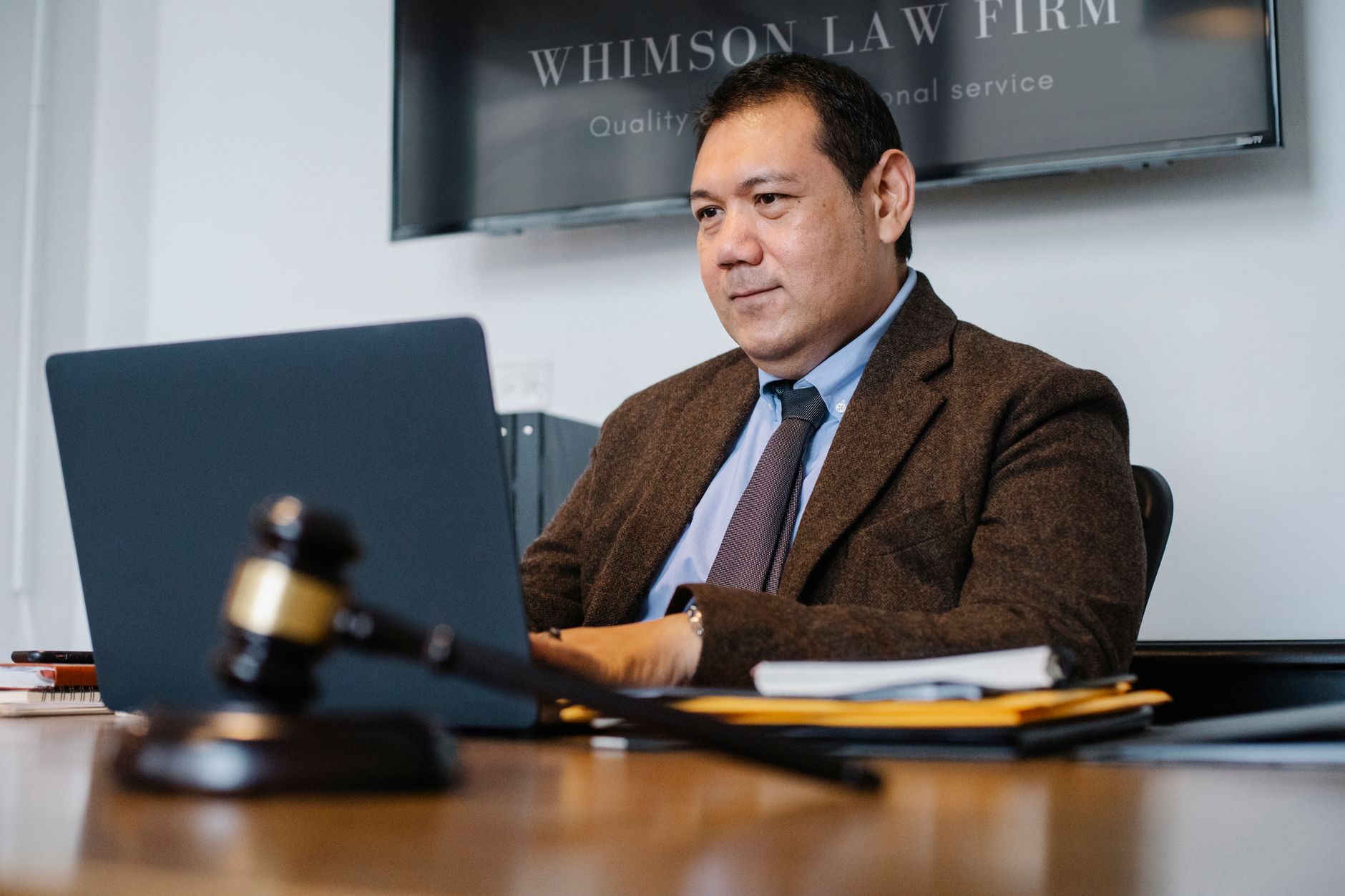 Um robô em uma bancada de tribunal, simulando o uso de inteligência artificial no sistema judicial, com um martelo de juiz ao lado.